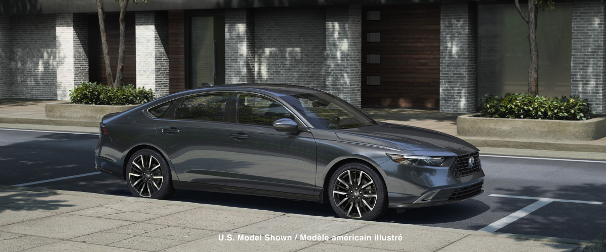 3/4 side view of grey Accord parked curbside on a sunny day in an upscale urban neighbourhood, with wooden townhome garage doors behind it.